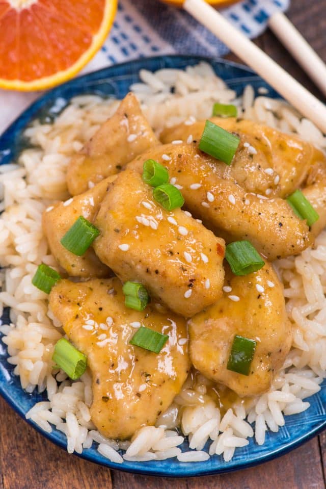 orange chicken on a bed of rice on blue plate