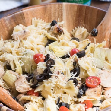 pasta salad in wood bowl with dressing bottle