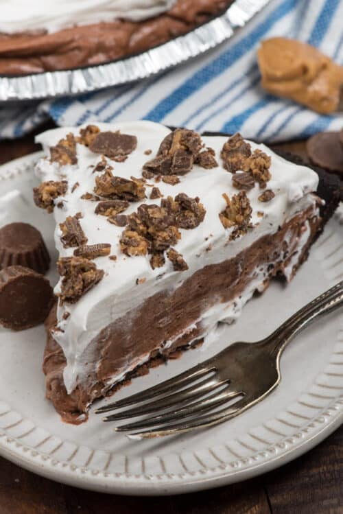 Slice of Peanut Butter Cup Pie on a white plate with a fork