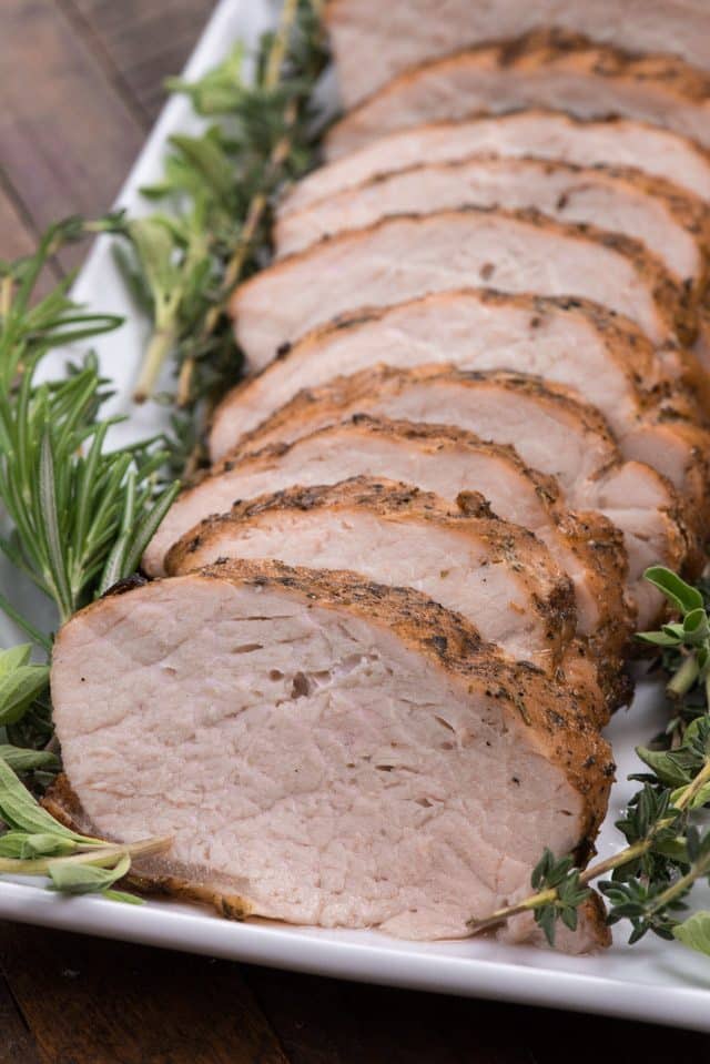 sliced grilled pork loin on a white platter