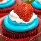 cupcakes with red white and blue frosting and a strawberry on top.