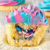 sliced open unicorn cupcake with sprinkles inside