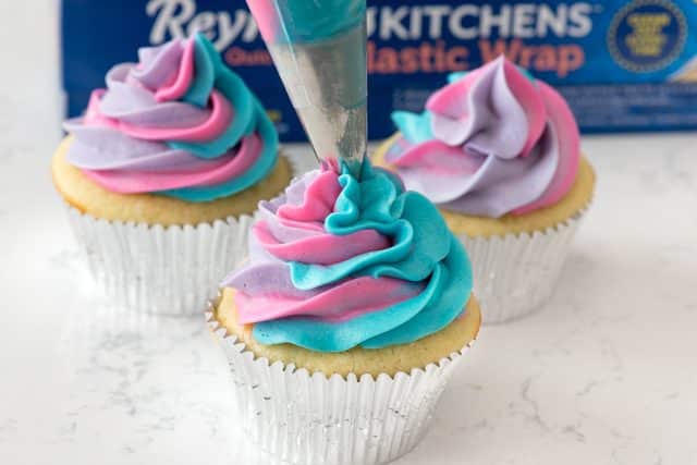 frosting a unicorn cupcake