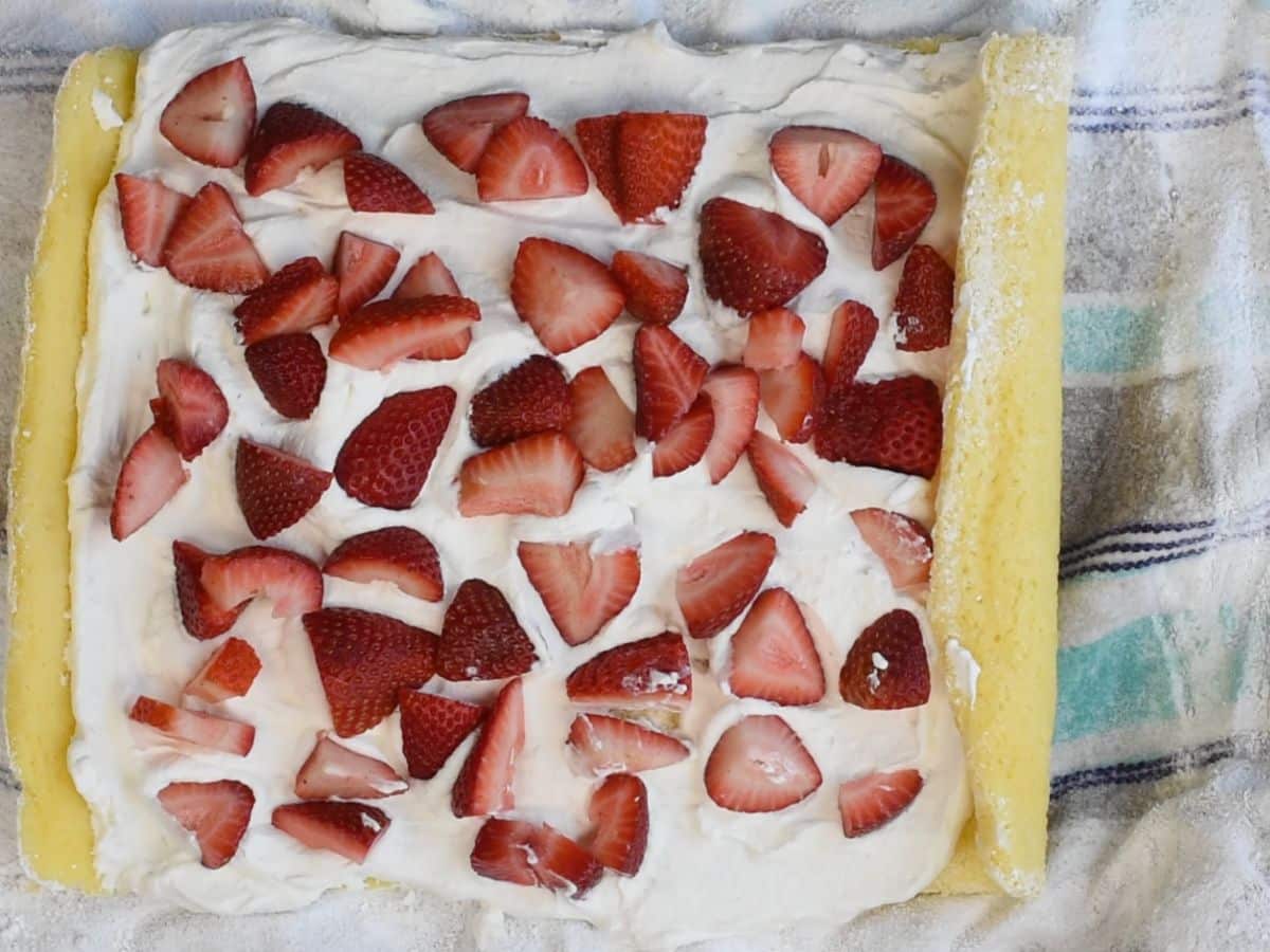 unrolled cake with whipped cream and berries inside.