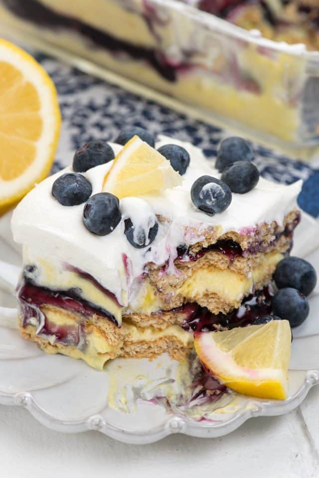 slice of lemon icebox cake on white plate with bite missing 