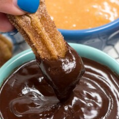 churro being dipped in chocolate ganache