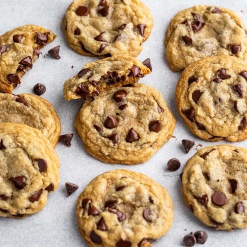 chocolate chip cookies on gray background with one cut in half