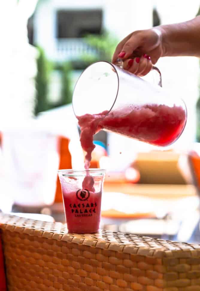 Cocktail being poured into a glass that says "Caesars Palace"