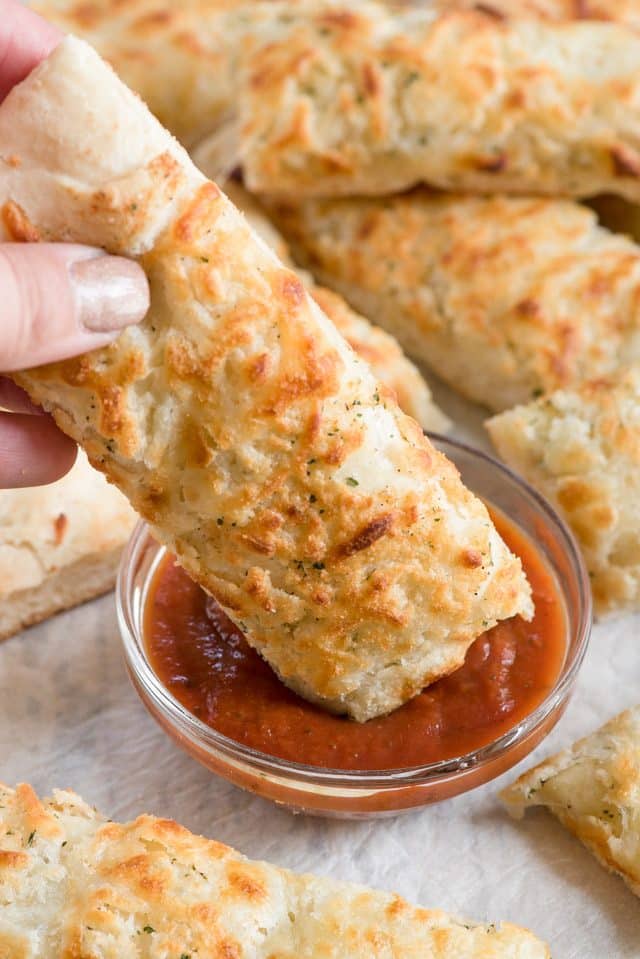 dipping cheesy ranch breadstick in pizza sauce