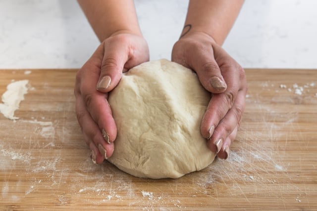 breadstick dough in a ball with hands