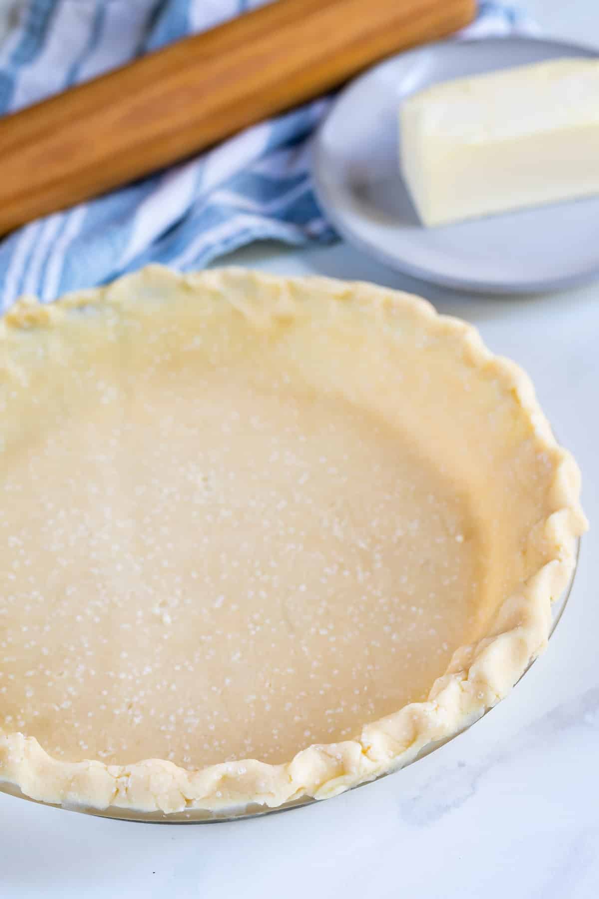 pie crust unbaked in pie plate with rolling pin behind