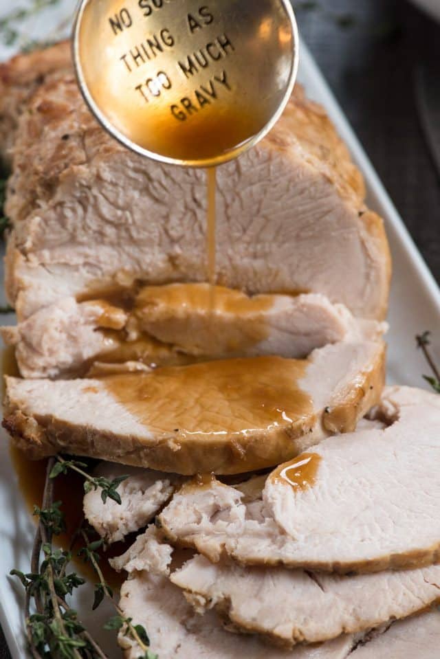 pouring gravy over slow cooker turkey breast
