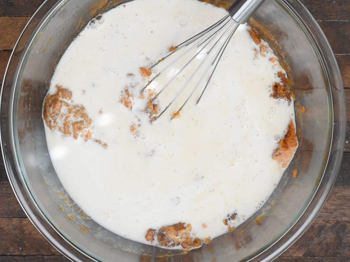 milk in pumpkin pie mixture with whisk.