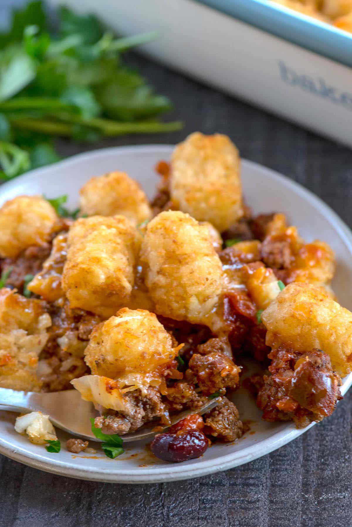 chili tater tot casserole on white plate with fork