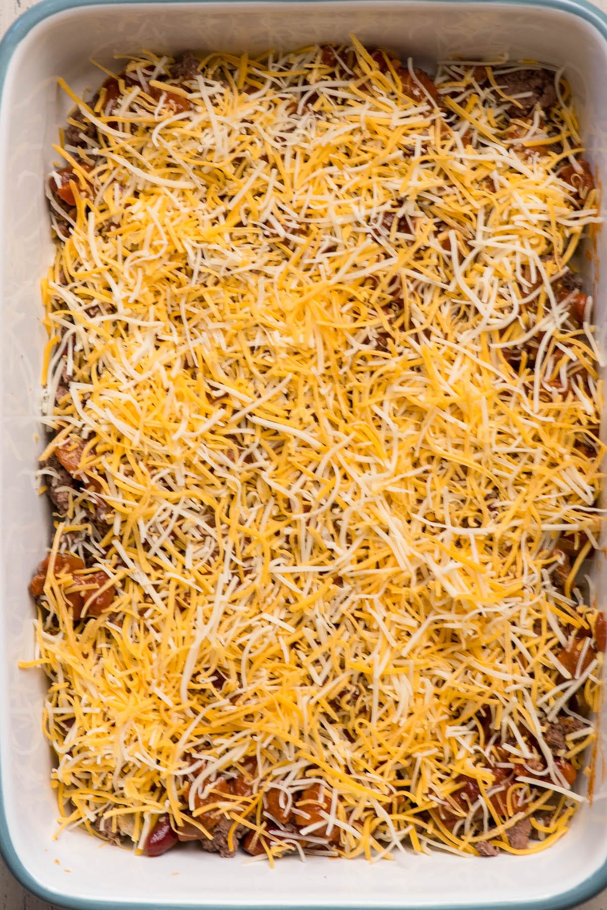9 by 13 pan with shredded cheese over chili and beef