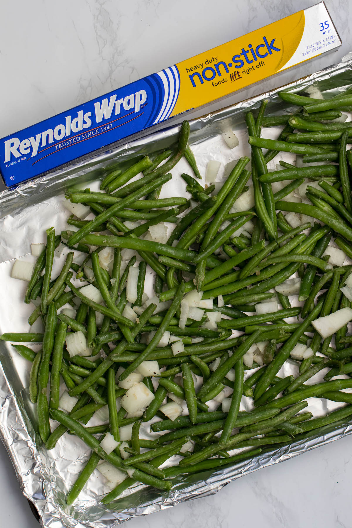 cookie sheet with green beans onions and foil