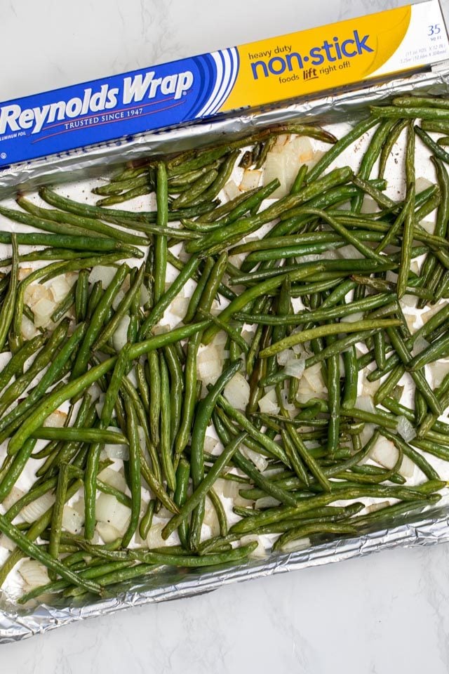 Green beans on a cookie sheet covered with aluminum foil