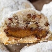 close up of snowball cookie cut in half filled with a peanut butter cup