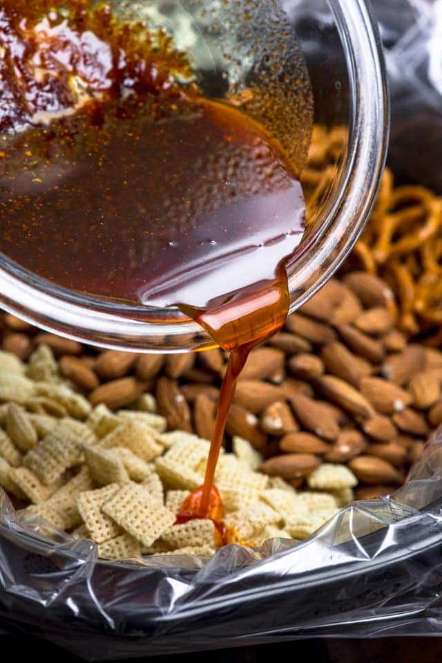 pouring bbq seasoning on Chex mix