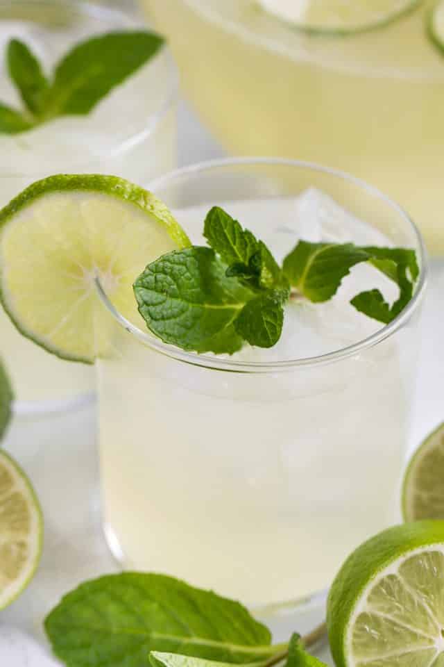 glass of vodka limeade punch with lime and mint