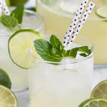 vodka limeade punch in glass with mint limes and straws