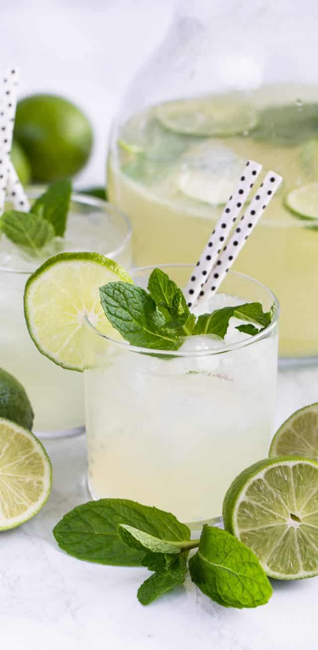 vodka limeade punch in glass with mint limes and straws