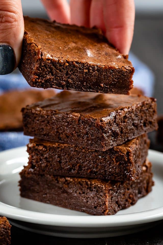 hand placing brownie on stack