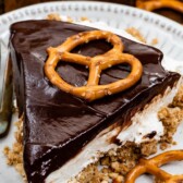 slice of chocolate covered pretzel no bake cheesecake on white plate