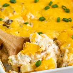 cheesy potatoes on spoon in casserole dish