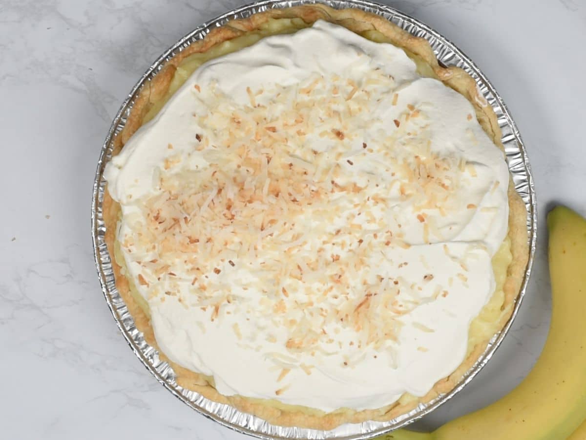 whipped cream on pie with toasted coconut.