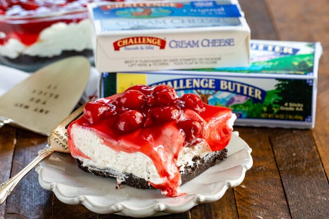 slice of cherry cheesecake dessert on white plate with challenge butter and cream cheese