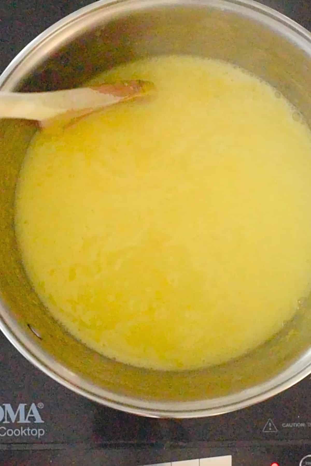 process of cooking lemon curd until it thickens in saucepan.