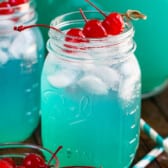 jar of blue drink with 3 cherries.