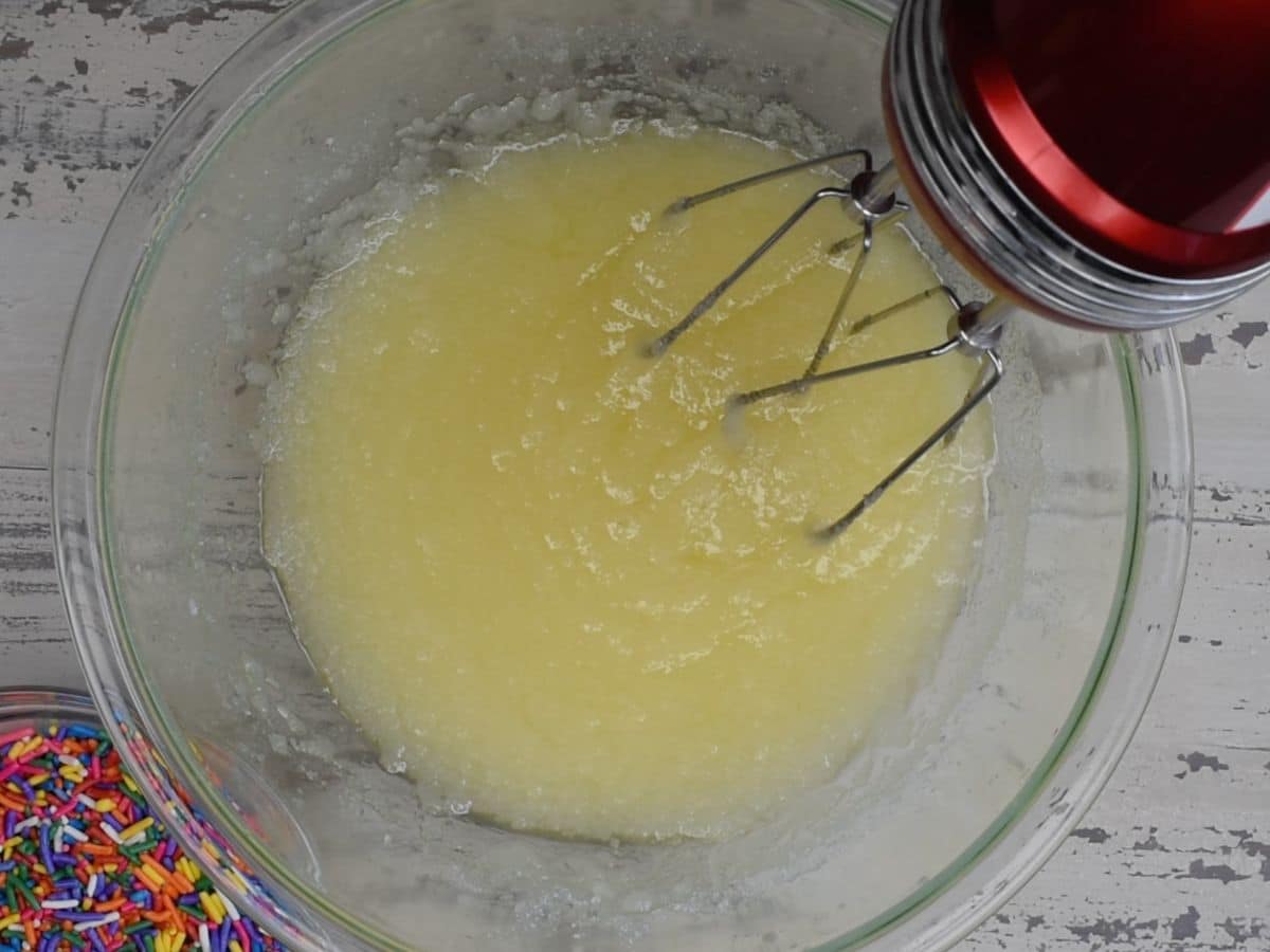 butter and sugar creamed in glass bowl with hand mixer