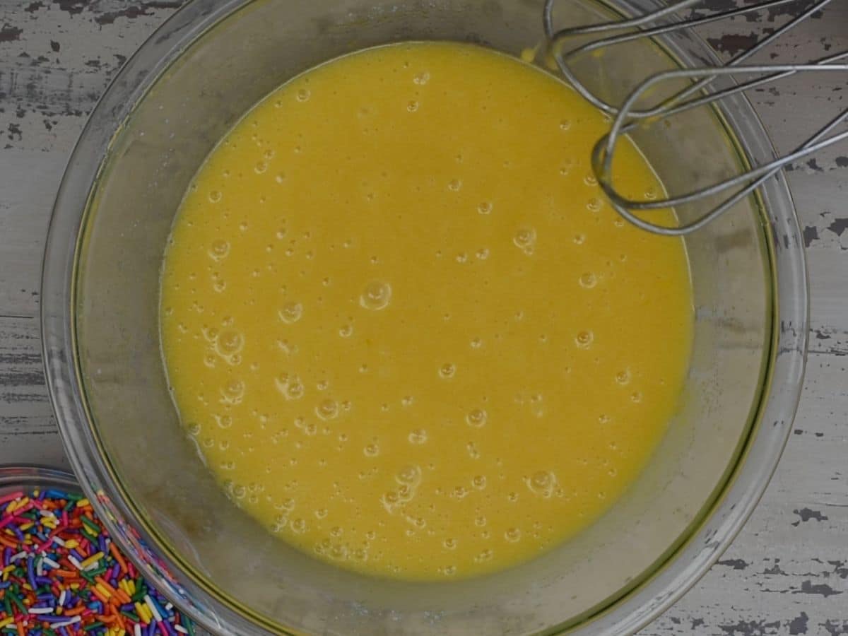 cake batter  in glass bowl with hand mixer.