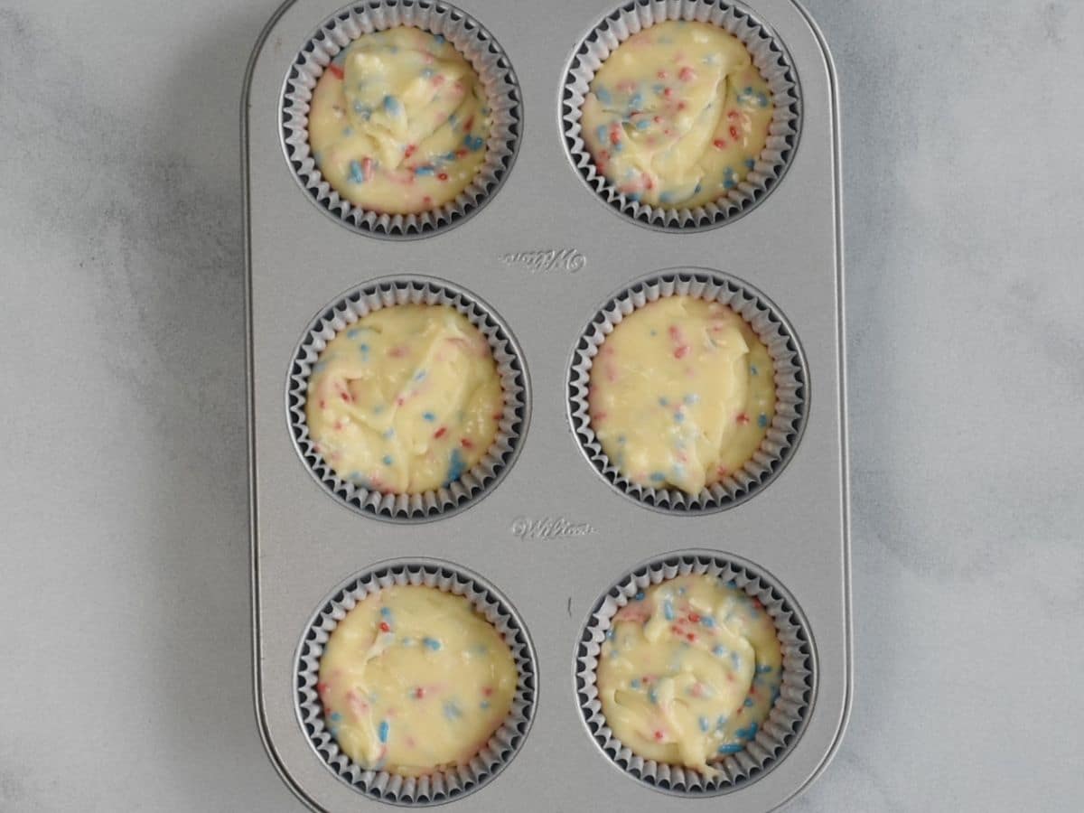 6 cavity cupcake pan with funfetti cake batter inside