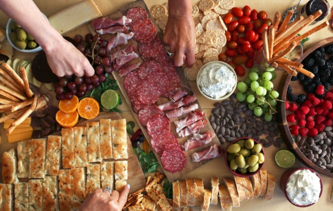 Charcuterie table with meats, breads, fruits, olives and cheese