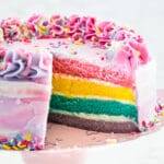 pastel rainbow cake with slice missing