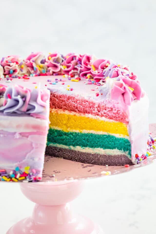 pastel rainbow cake with slice missing