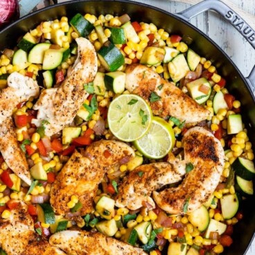 spicy chicken with corn and zucchini in pan
