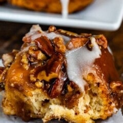 sticky bun with icing on a white plate