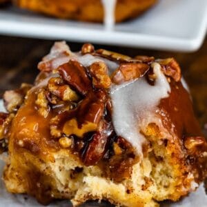 sticky bun with icing on a white plate