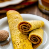 3 pumpkin pancake rolls on white plate