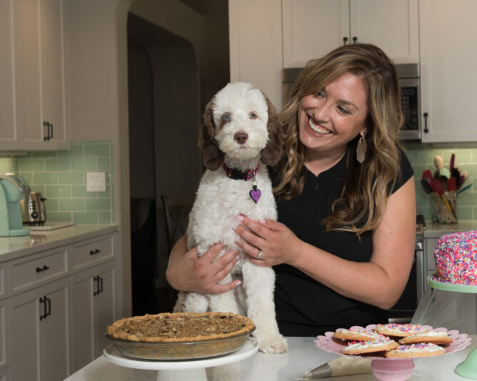woman with dog on counter in kitchen