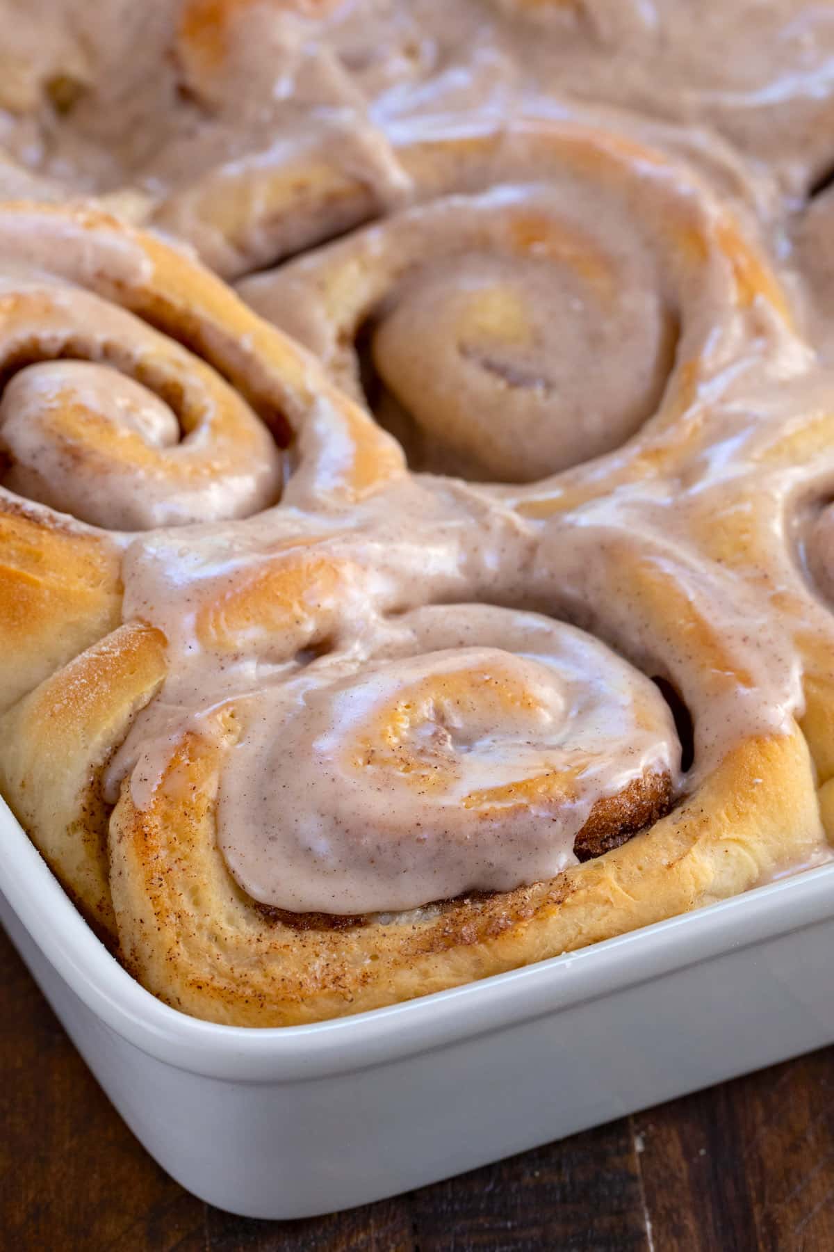 corner of cinnamon roll pan showing roll with icing