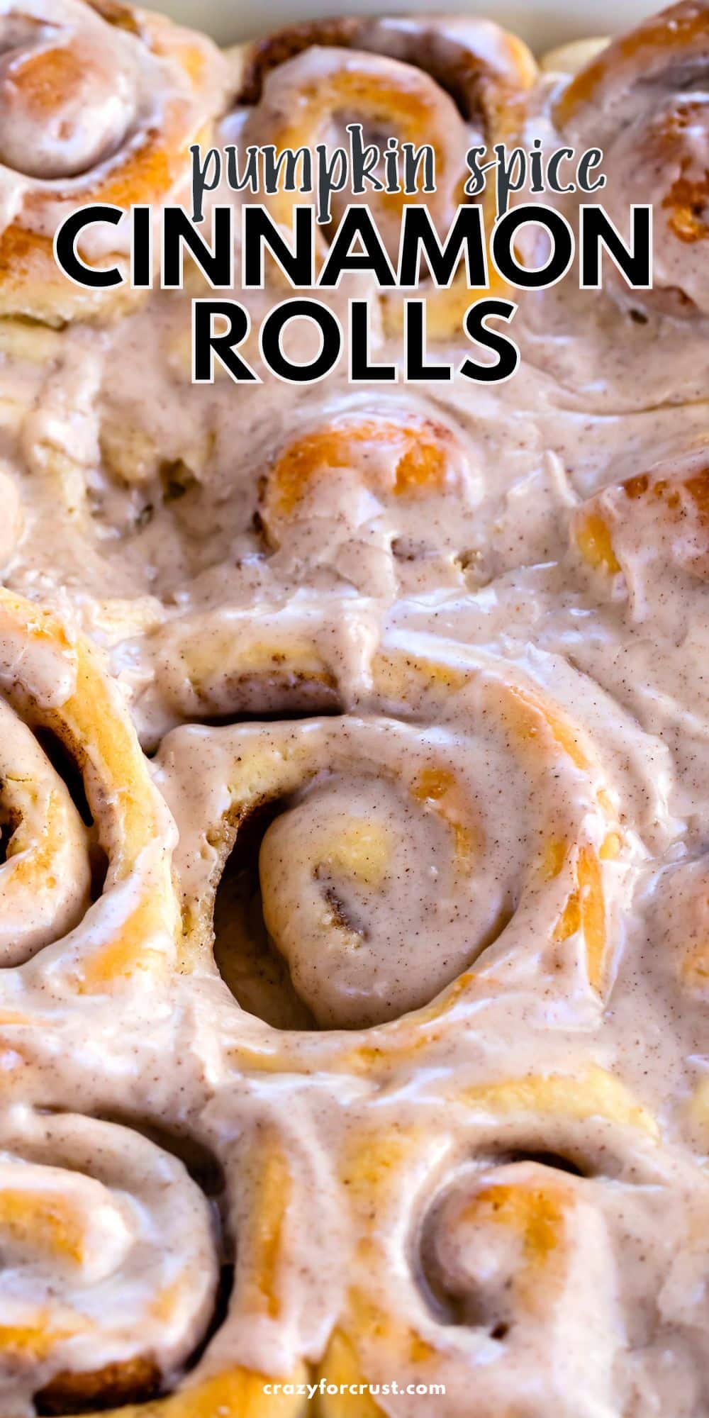 close up of pan of cinnamon rolls with icing