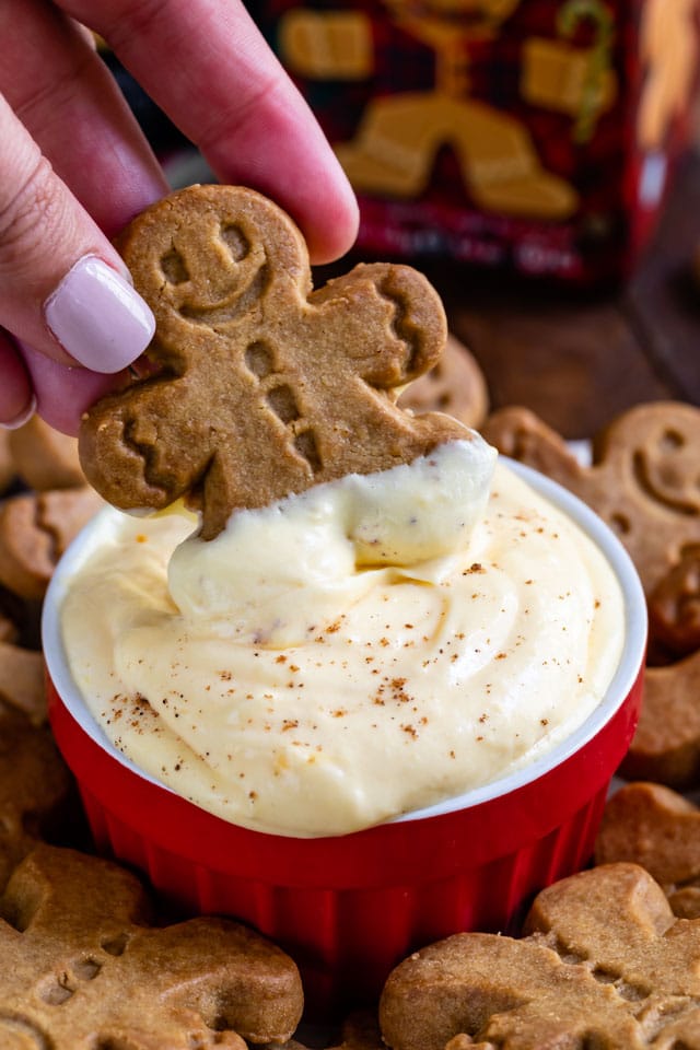 eggnog pudding dip with hand dipping gingerbread man