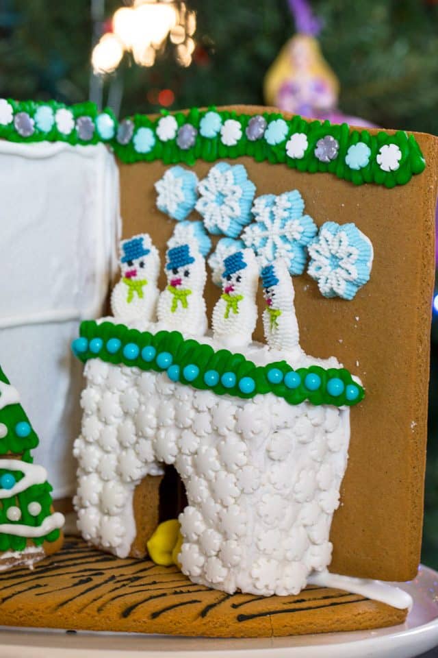 Gingerbread house fireplace with 4 snowmen on the mantel