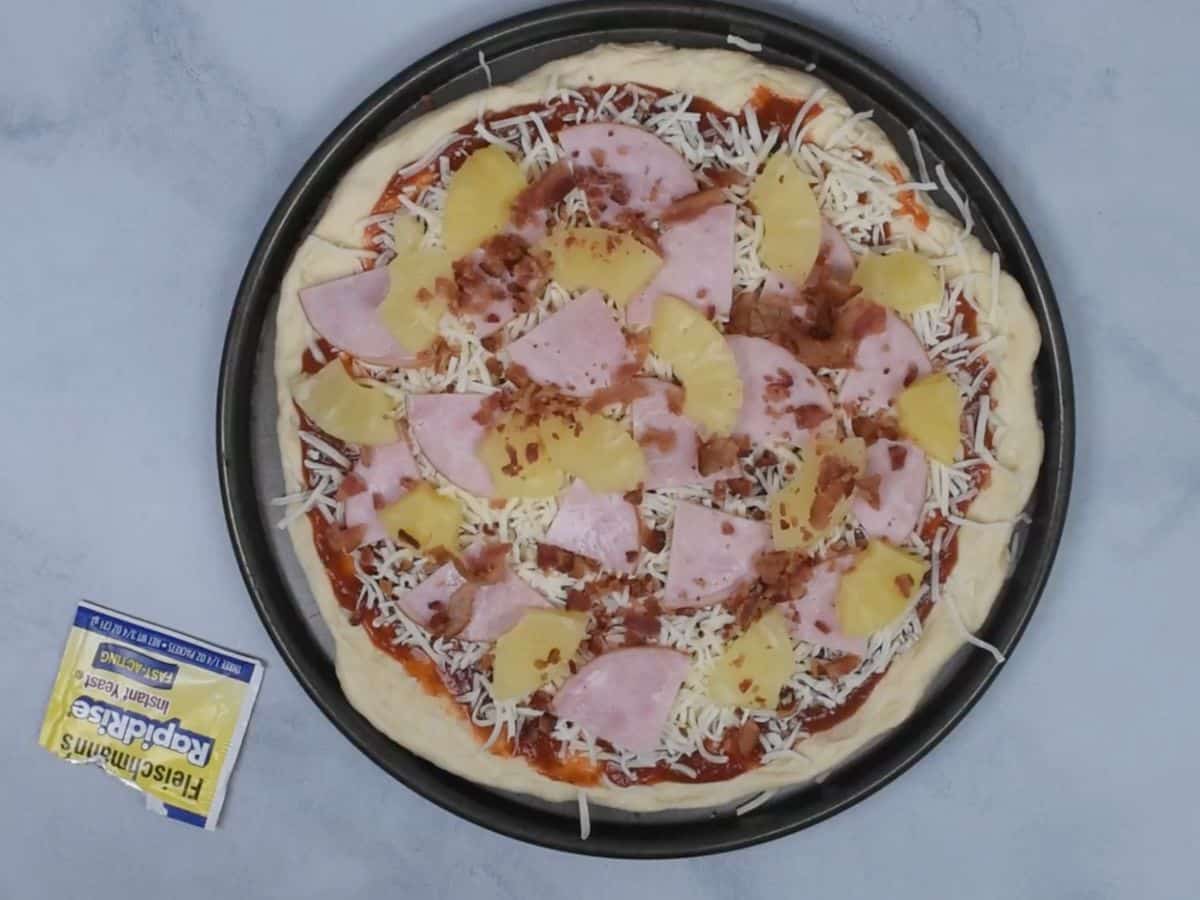 hawaiian pizza toppings on pizza before baking.