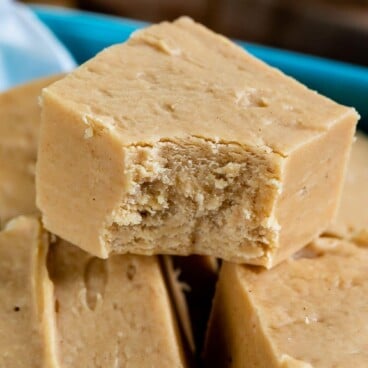peanut butter fudge in a stack with one bite missing and words on photo